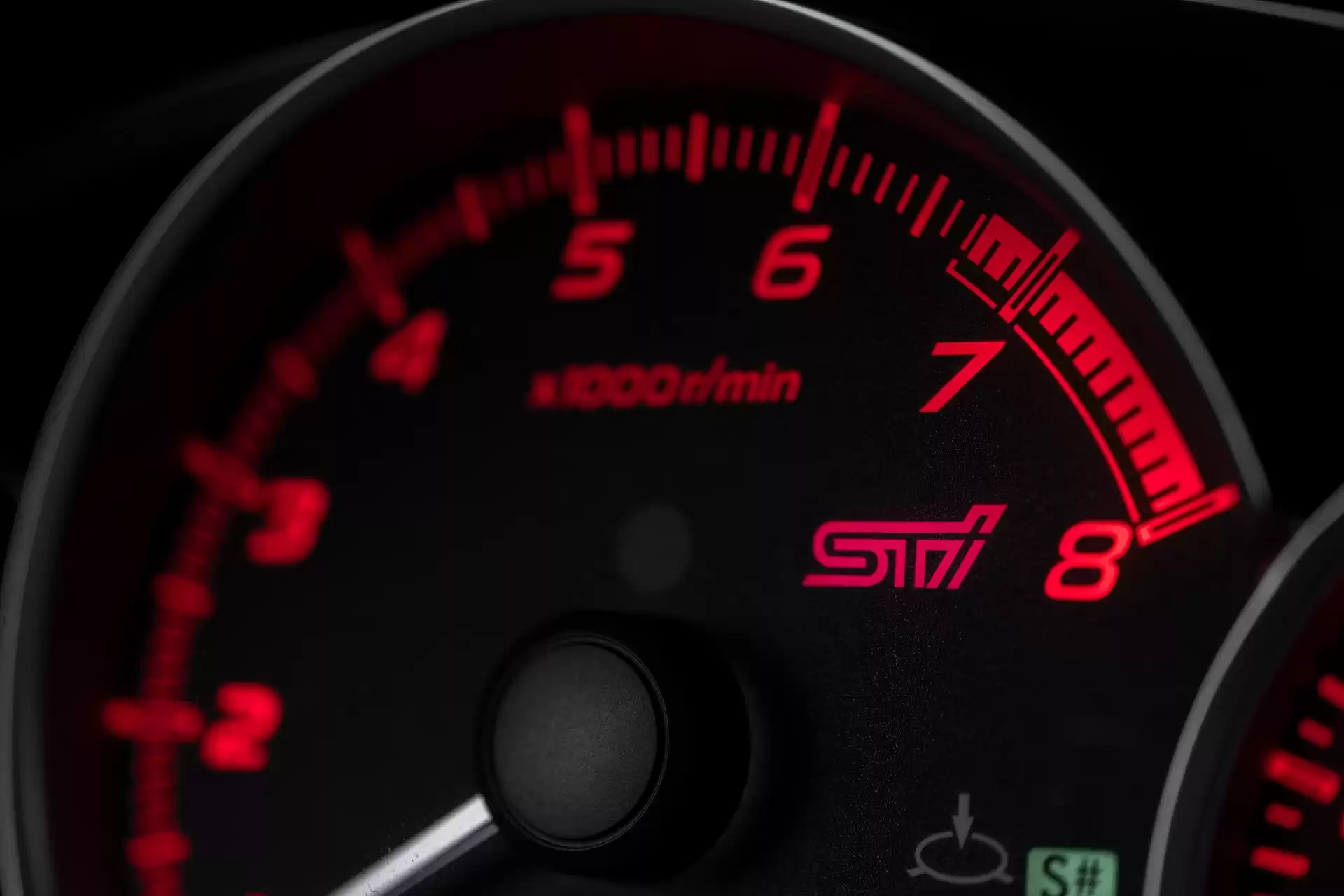 Photograph of a red speedometer on a black dash